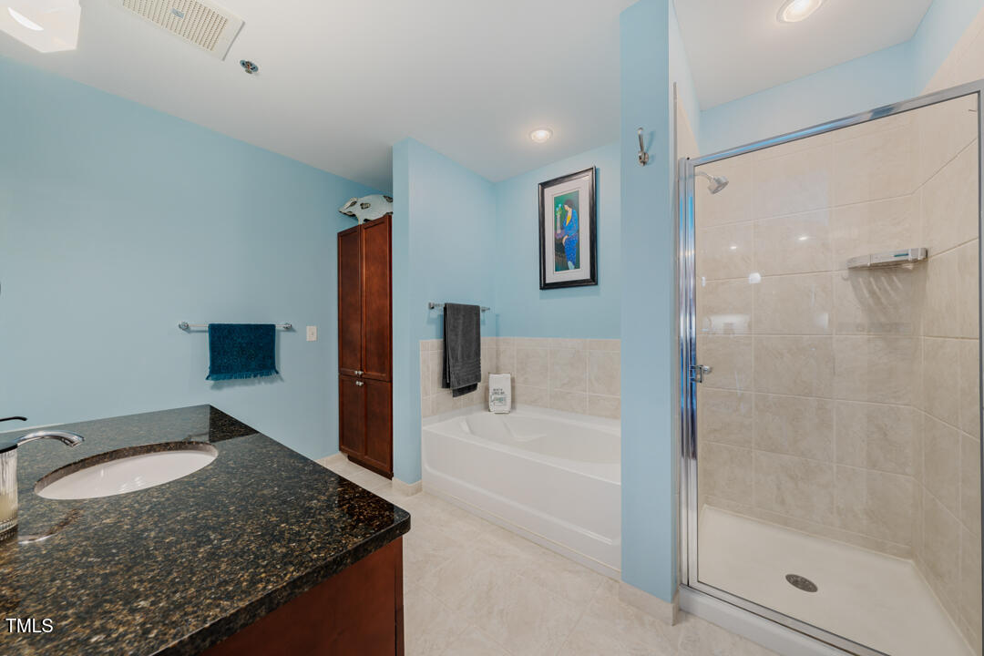 301 Fayetteville Street, Unit 3104 Raleigh, NC 27601 - Photo 21 of 44 a bathroom with a granite countertop sink and mirror
