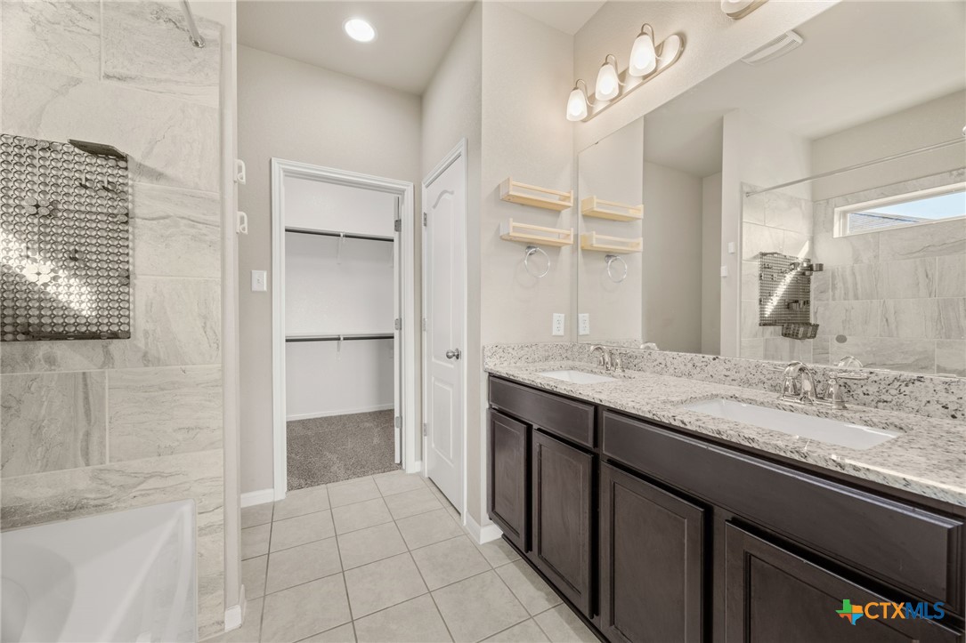 7617 Lee Hall Loop Temple, TX 76502 - Photo 13 of 26 a bathroom with a granite countertop sink a mirror and a shower