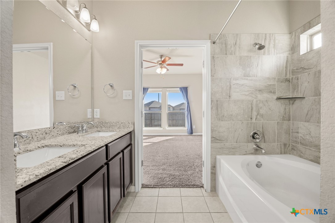 7617 Lee Hall Loop Temple, TX 76502 - Photo 14 of 26 a bathroom with a granite countertop sink a bathtub and a shower