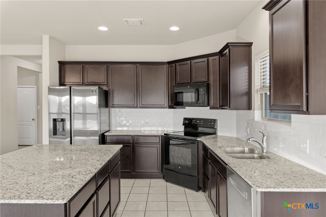 7617 Lee Hall Loop Temple, TX 76502 - Photo 9 of 26 a kitchen with stainless steel appliances granite countertop a sink stove and refrigerator