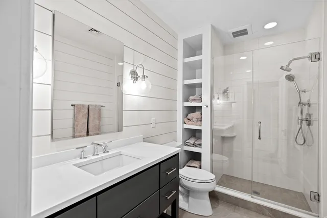 a bathroom with a sink a toilet and shower