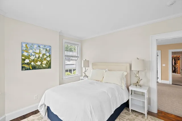 a bedroom with a bed and painting on the wall