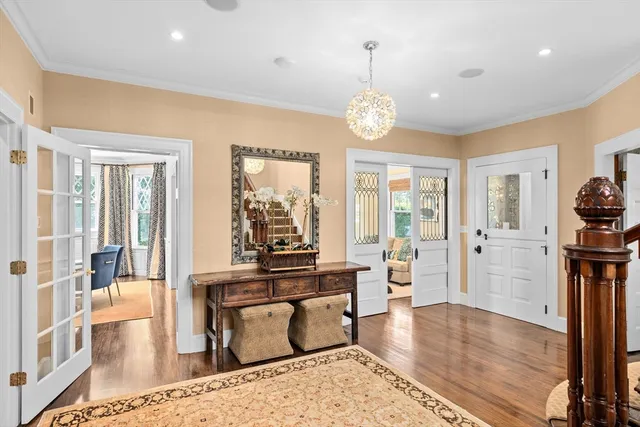 a view of a dining room and livingroom with furniture wooden floor a chandelier