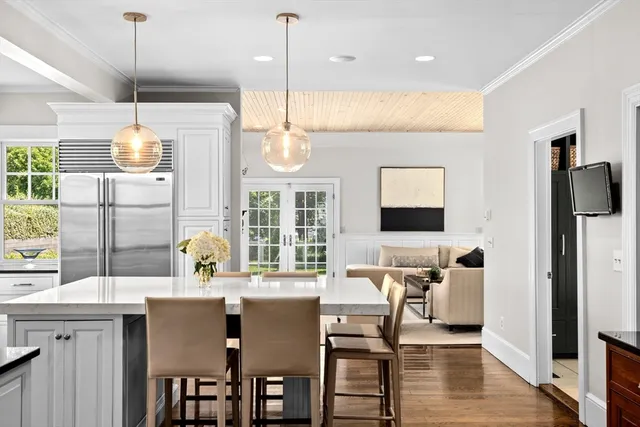 a kitchen with stainless steel appliances granite countertop a stove a refrigerator a kitchen island a table and chairs