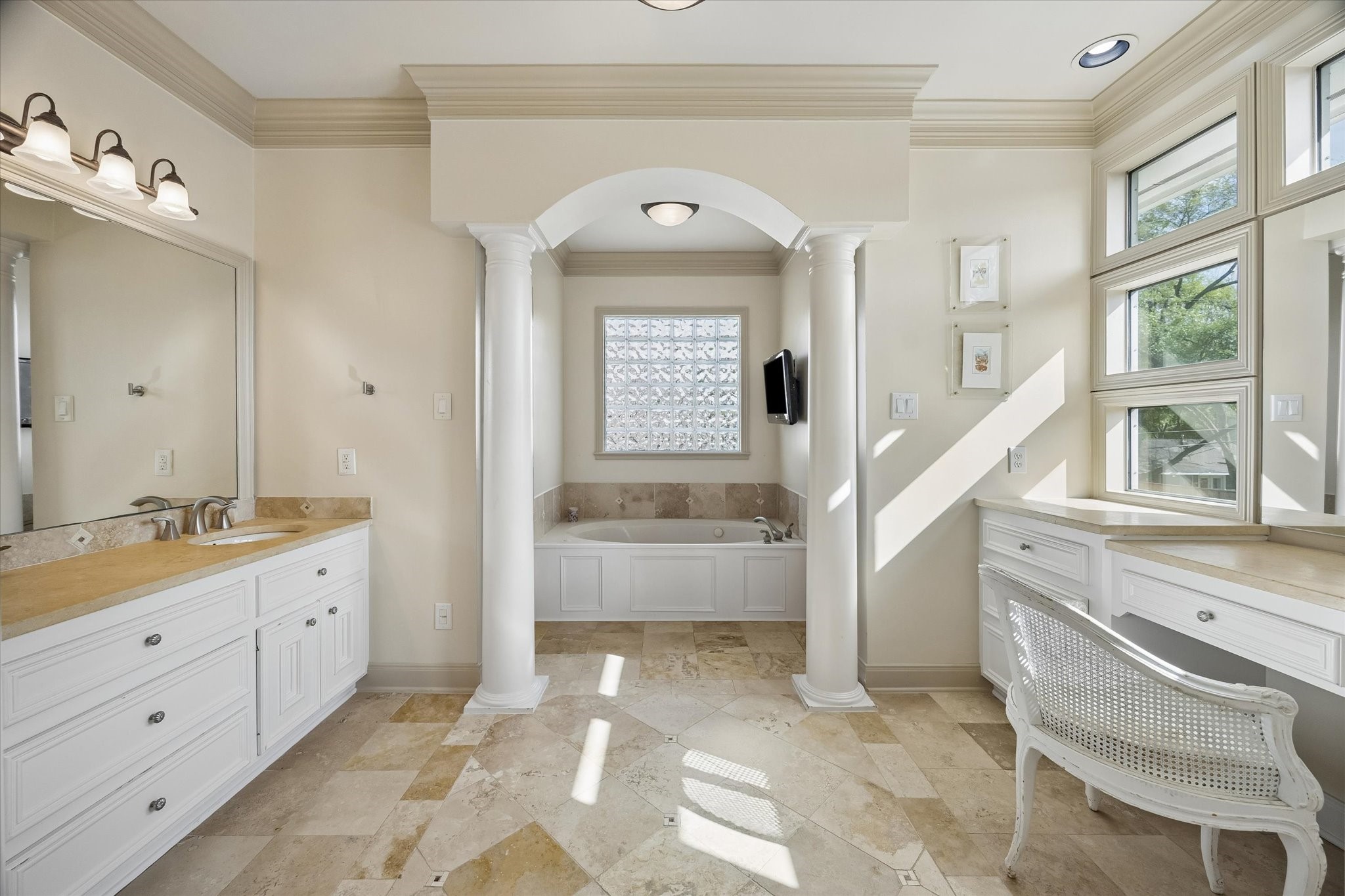 4606 Birch Street Bellaire, TX 77401 - Photo 27 of 45 a bathroom with a granite countertop sink a large mirror and a bathtub next to a window