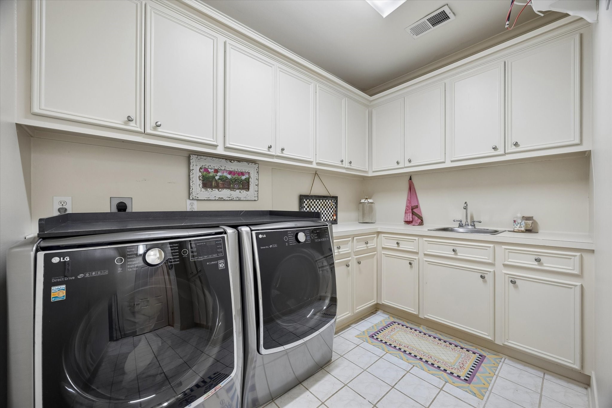 4606 Birch Street Bellaire, TX 77401 - Photo 39 of 45 a utility room with granite countertop cabinets washer and dryer