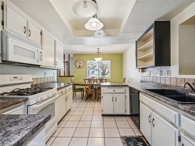 a kitchen with a stove a sink a microwave and cabinets