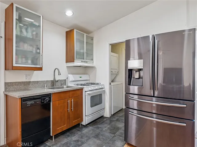 a kitchen with stainless steel appliances granite countertop a refrigerator sink and stove