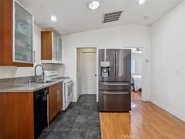 a kitchen with a refrigerator sink and wooden floor