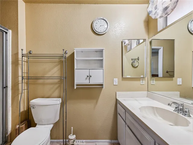 a bathroom with a granite countertop toilet sink and mirror