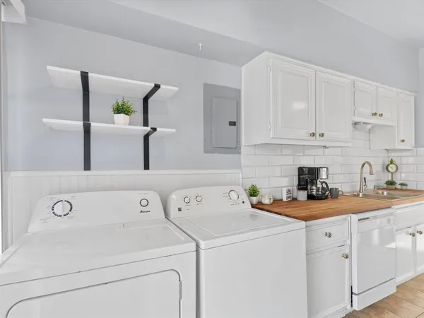 a view of a kitchen with sink washer and dryer