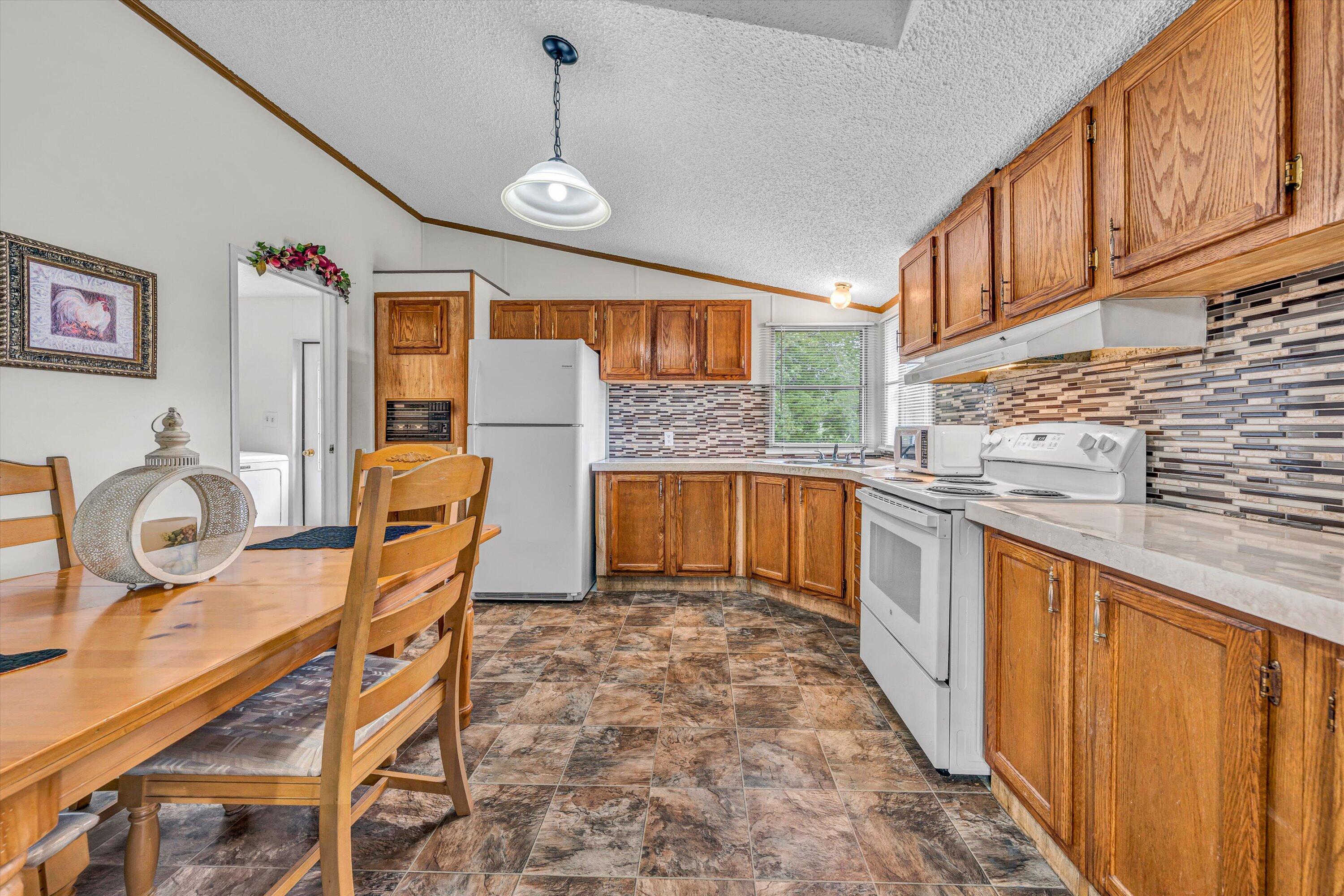 1060 Lynch Road Moneta, VA 24121 - Photo 8 of 18 a very nice looking kitchen with granite countertop a stove a sink a dining table and chairs