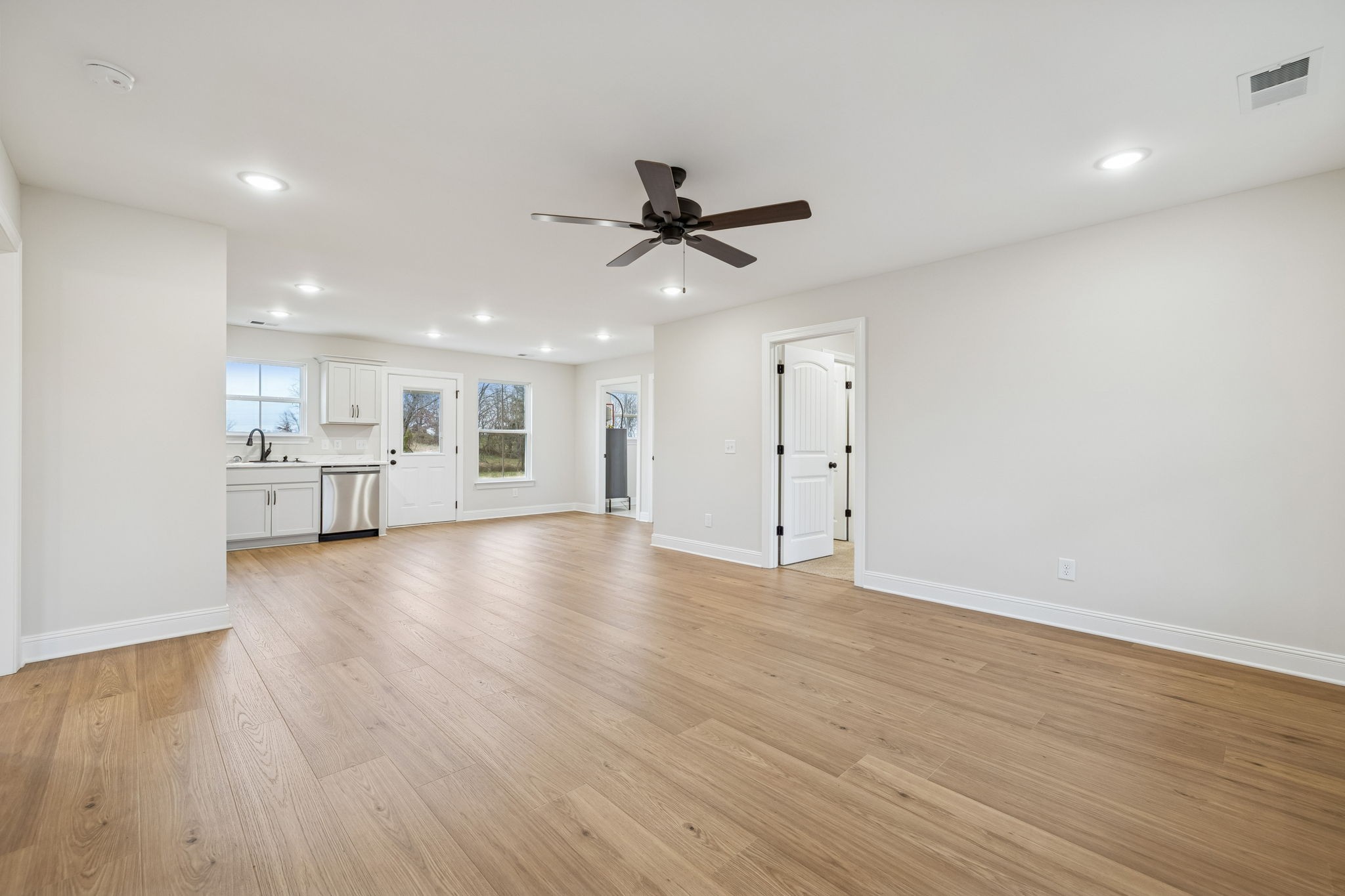 1035 Landing Lane Adams, TN 37010 - Photo 7 of 26 a view of empty room with wooden floor and kitchen view