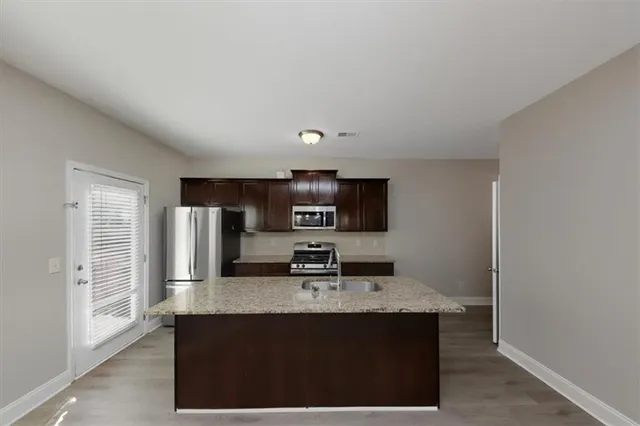 a kitchen with stainless steel appliances a sink and refrigerator