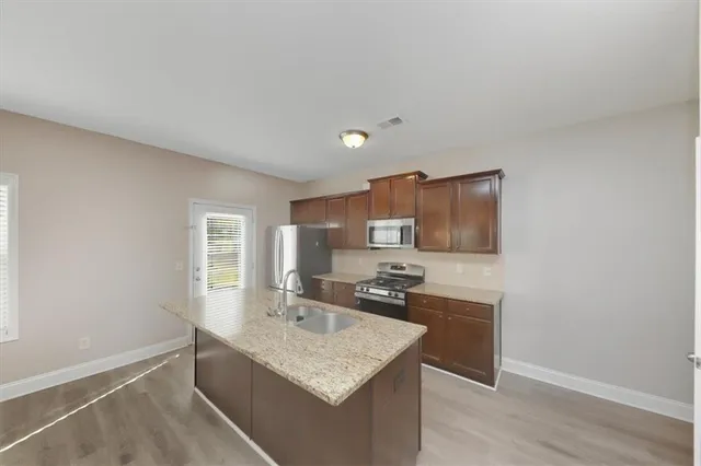 a kitchen with kitchen island granite countertop a sink stove and refrigerator