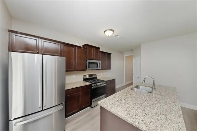 a kitchen with a refrigerator sink and cabinets