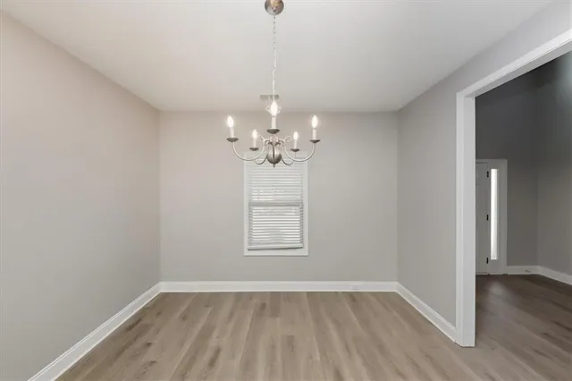 a view of a room with wooden floor chandelier and window