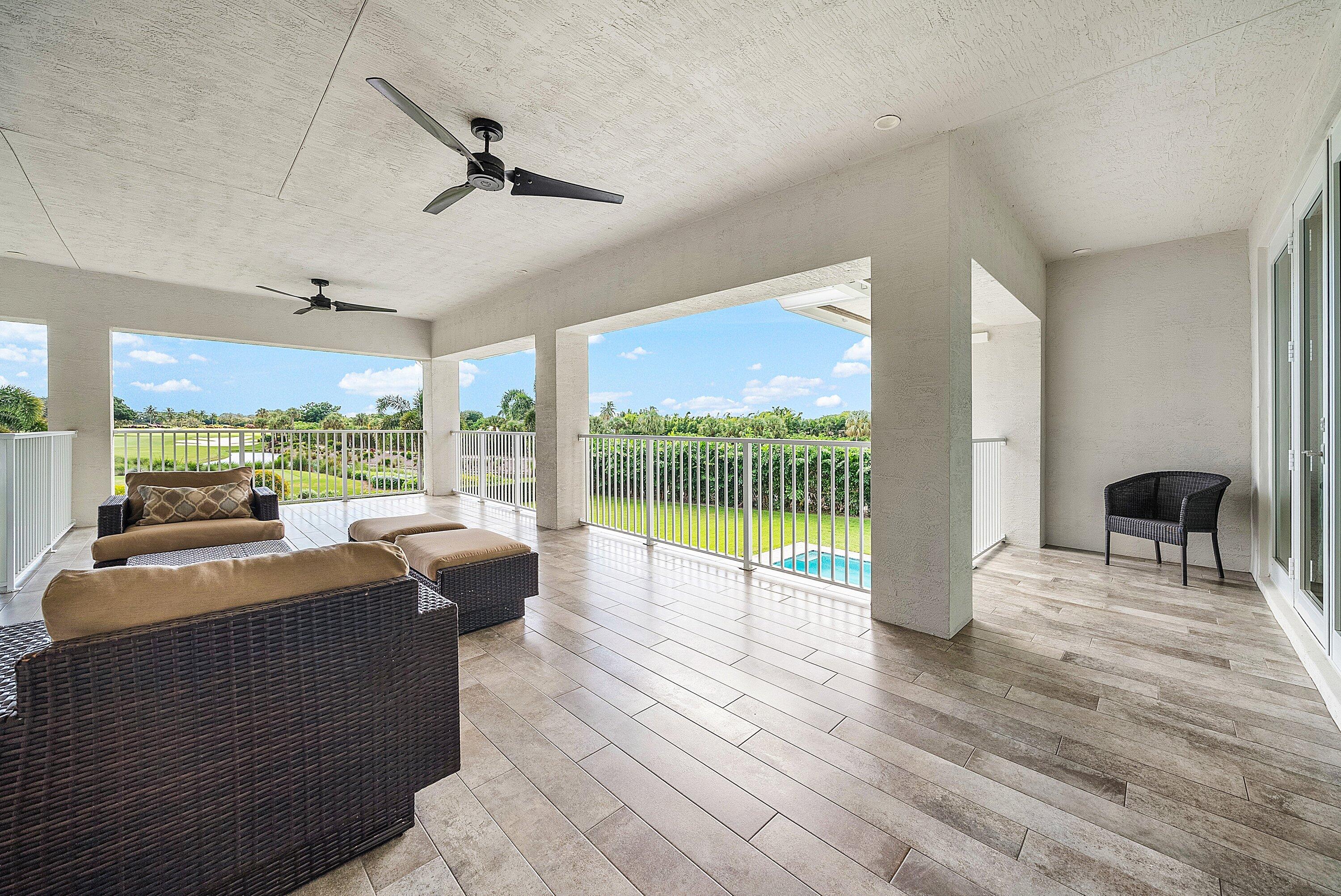 4600 Bocaire Boulevard Boca Raton, FL 33487 - Photo 50 of 98 a living room with couch floor to ceiling window and a ceiling fan