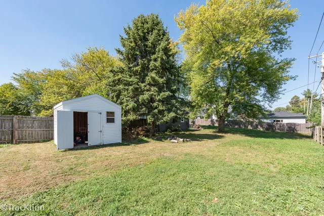 a view of a backyard with a tree and a garden