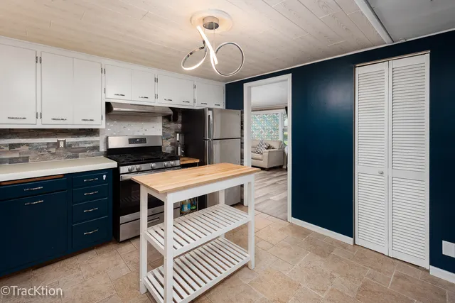 a kitchen with stainless steel appliances a stove a refrigerator and cabinets