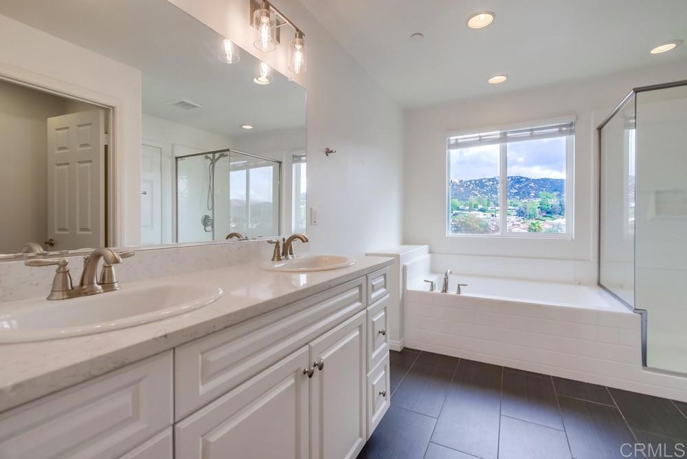 13109 Beacon View Lane El Cajon, CA 92021 - Photo 27 of 36 a bathroom with a double vanity sink bathtub and next to a window