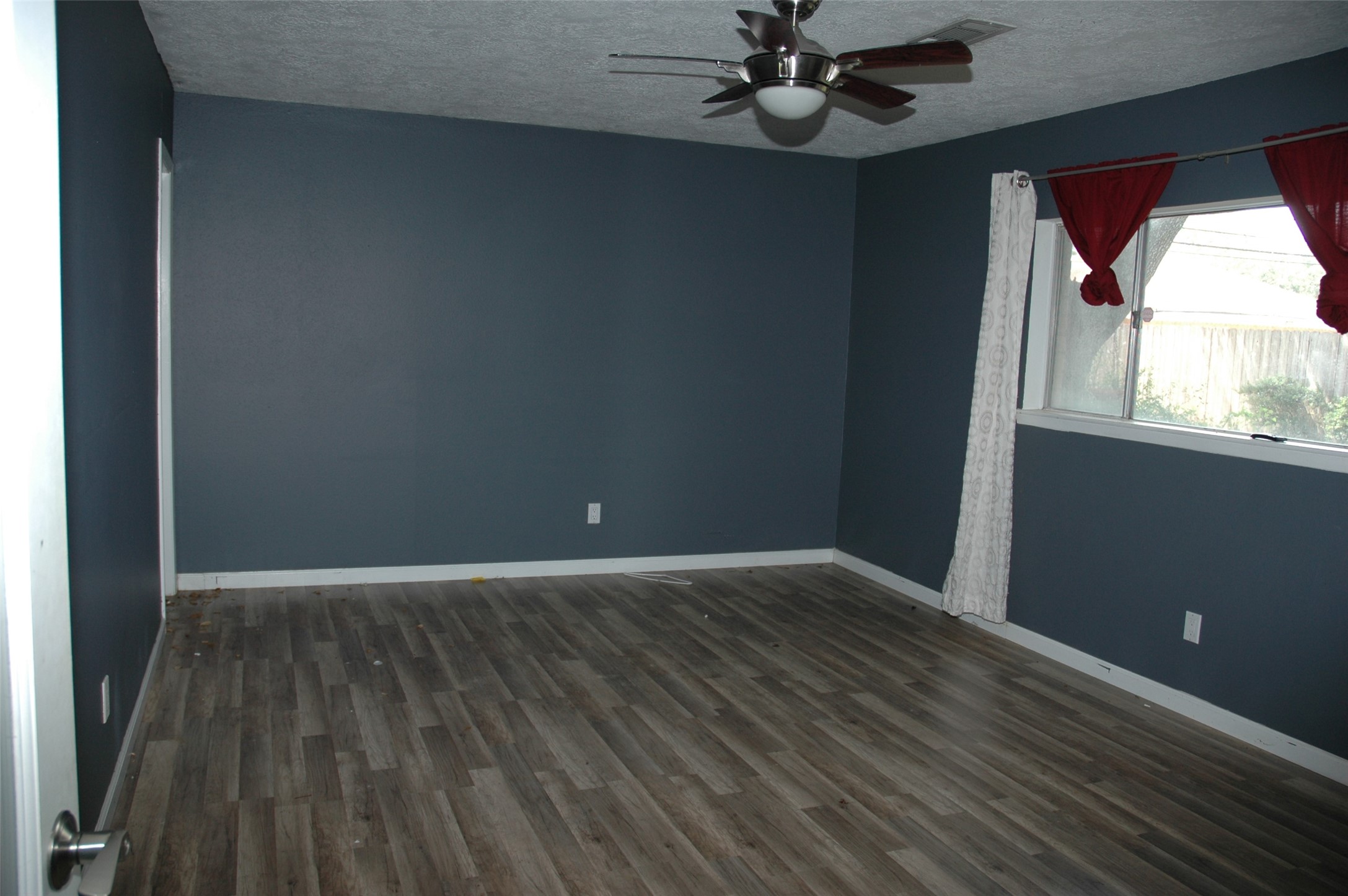 11618 Hillcroft Street Houston, TX 77035 - Photo 5 of 6 an empty room with wooden floor fan and windows