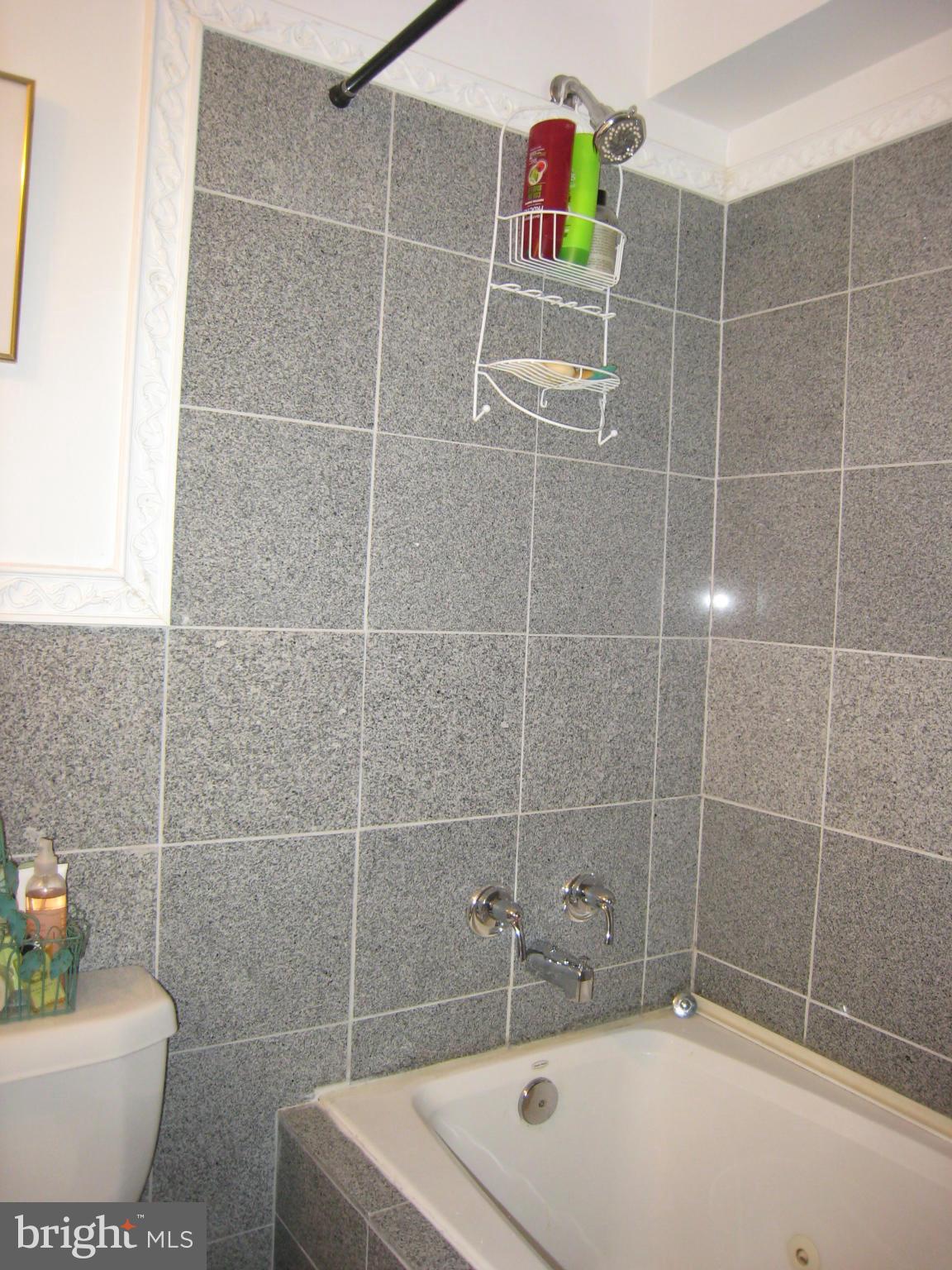 2826 Ridge Road Baltimore, MD 21244 - Photo 23 of 30 a bathroom with a white bathtub and a shower