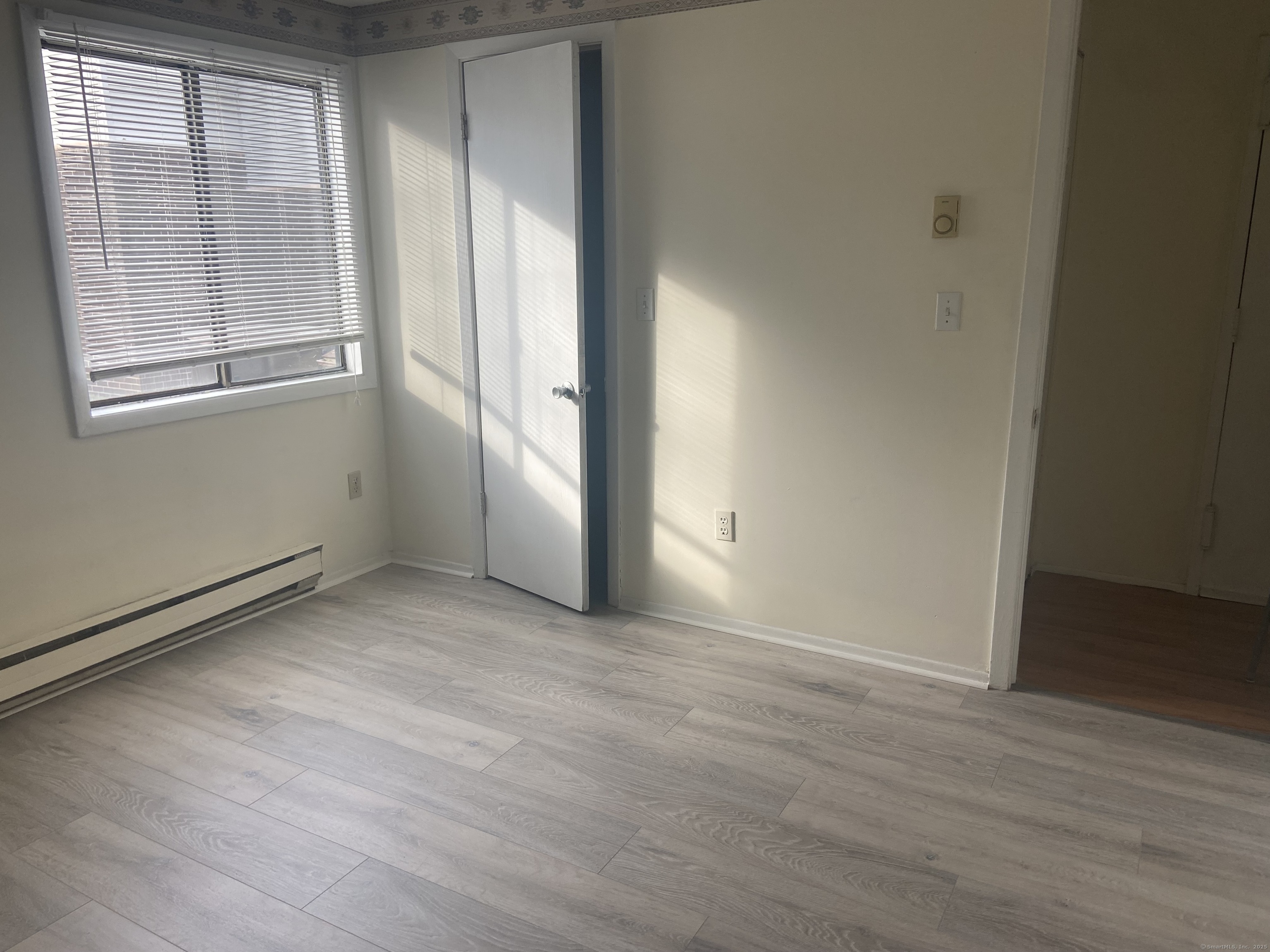 7 Padanaram Road, Unit J238 Danbury, CT 06811 - Photo 13 of 18 an empty room with wooden floor and windows