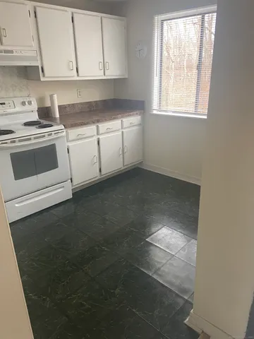 a kitchen with granite countertop white cabinets and white appliances