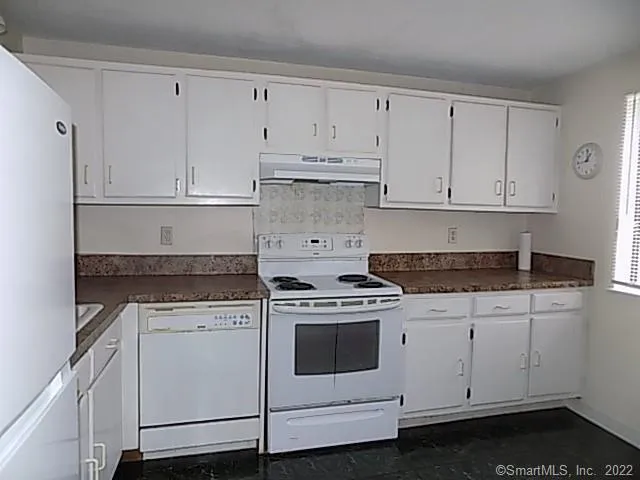 a kitchen with white cabinets and white appliances