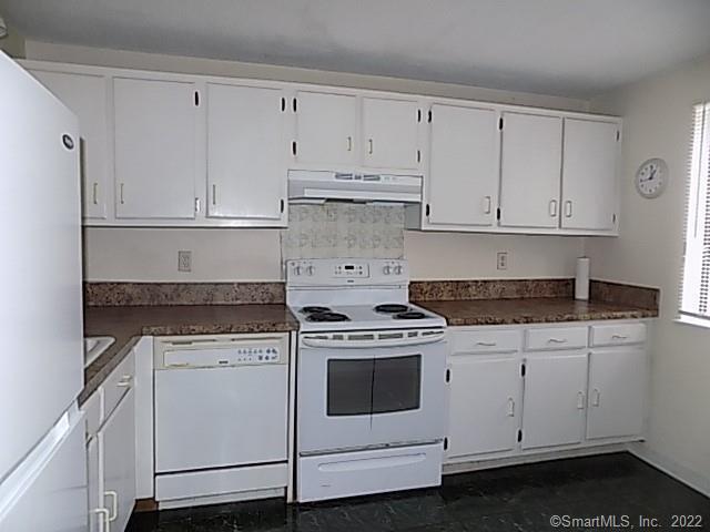 7 Padanaram Road, Unit J238 Danbury, CT 06811 - Photo 6 of 18 a kitchen with white cabinets and white appliances