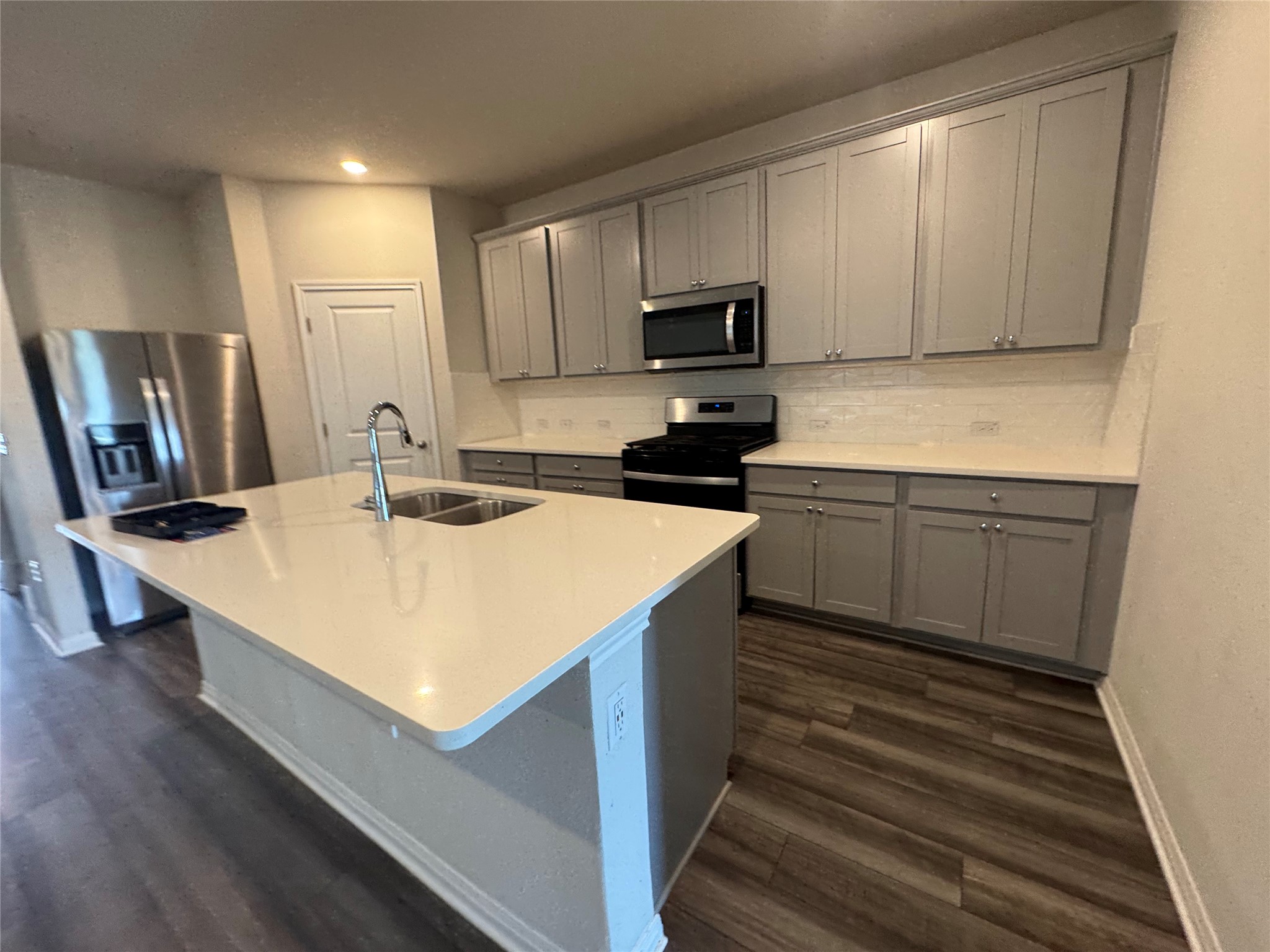 6400 Rounded Pebble Lane Buda, TX 78610 - Photo 2 of 34 a kitchen with kitchen island a sink appliances and cabinets