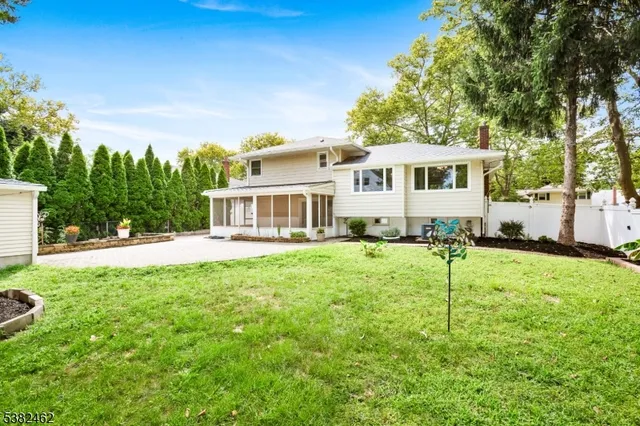 a view of a house with backyard and a tree