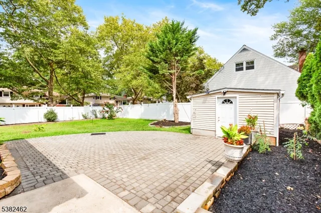 a view of house with a yard and potted plants