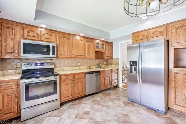 a kitchen with granite countertop a refrigerator stove and microwave