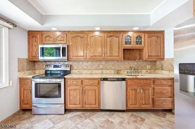 a kitchen with stainless steel appliances granite countertop a stove a sink and a microwave