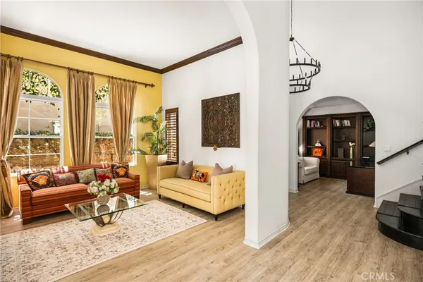 a view of a dining room and livingroom with furniture wooden floor a chandelier