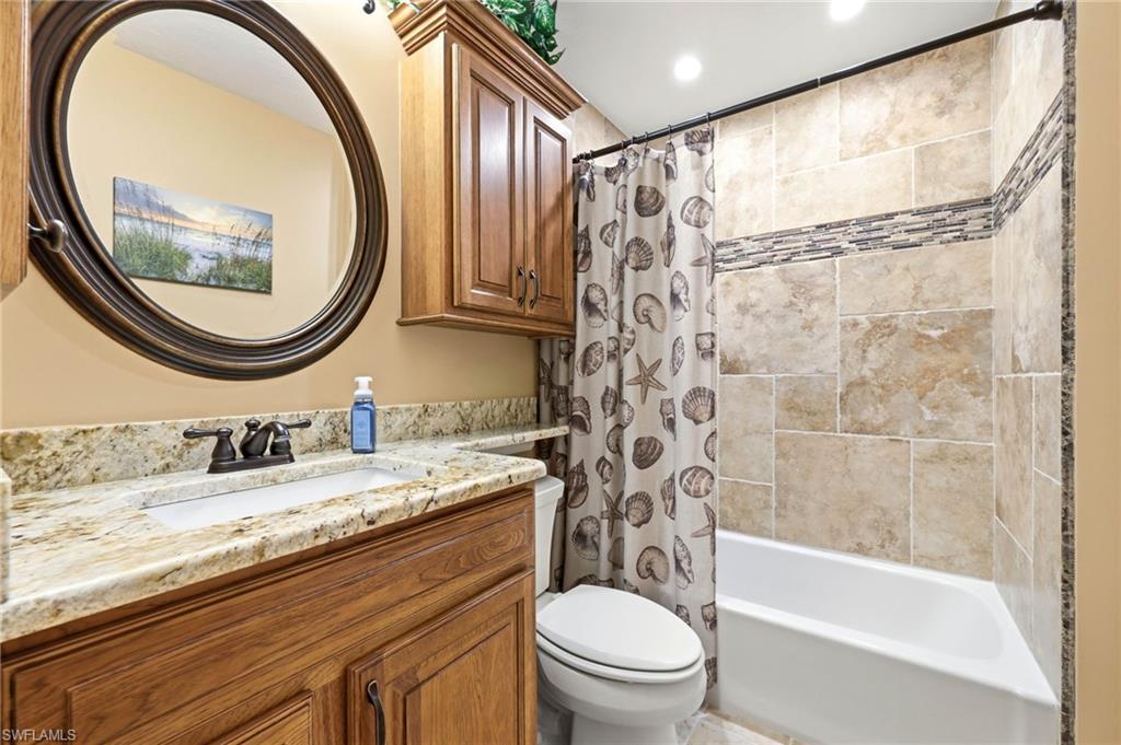 5201 31st Place Southwest Naples, FL 34116 - Photo 15 of 24 a bathroom with a granite countertop toilet a sink and a mirror