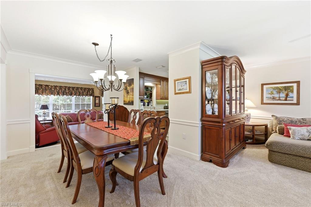 5201 31st Place Southwest Naples, FL 34116 - Photo 4 of 24 a dining room with furniture a chandelier and wooden floor