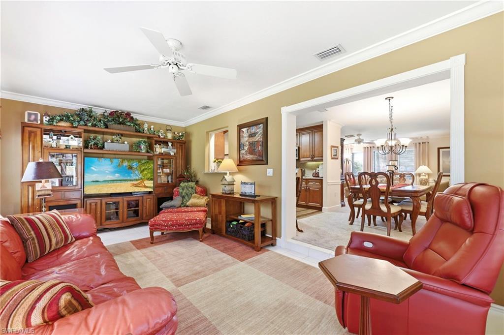 5201 31st Place Southwest Naples, FL 34116 - Photo 7 of 24 a living room with furniture a fireplace and a chandelier