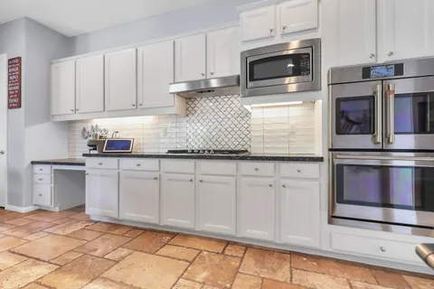 a kitchen with stainless steel appliances granite countertop a refrigerator sink and stove