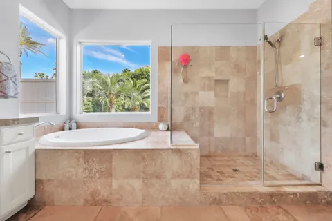 a white bath tub sitting in a bathroom next to a window