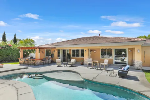 a view of a house with swimming pool and sitting area