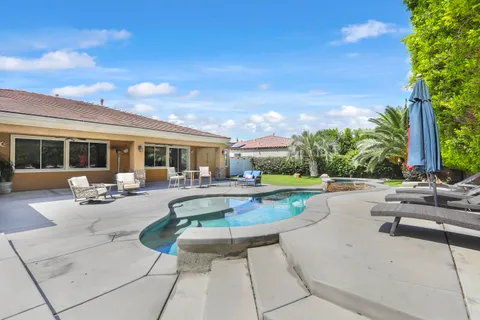 a view of a house with swimming pool and sitting area