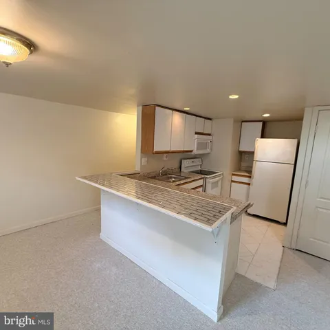 a kitchen with stainless steel appliances granite countertop a sink a refrigerator and a stove