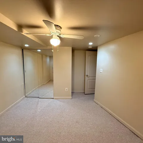 an empty room with a ceiling fan and bathroom
