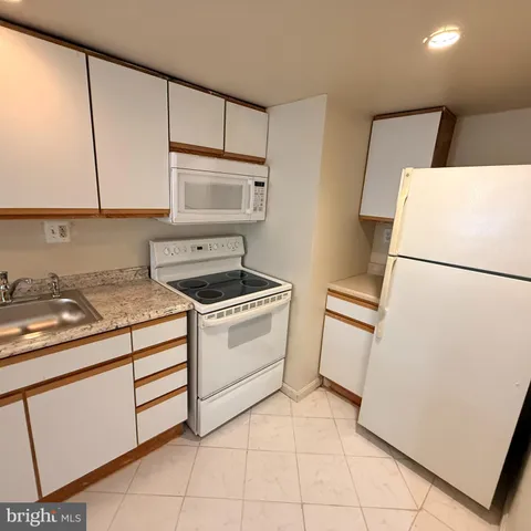 a kitchen with a stove sink and cabinets
