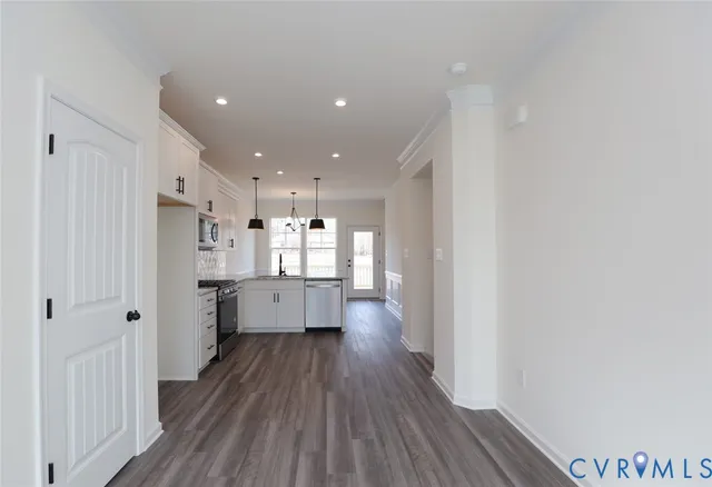 a kitchen with stainless steel appliances a refrigerator a sink dishwasher and a stove with wooden floor