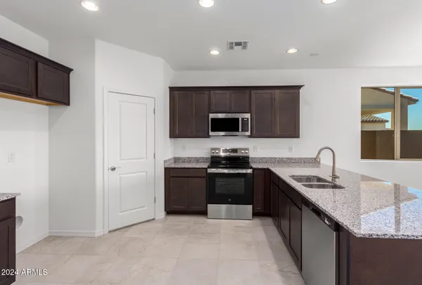 a kitchen with stainless steel appliances granite countertop a sink dishwasher stove and refrigerator