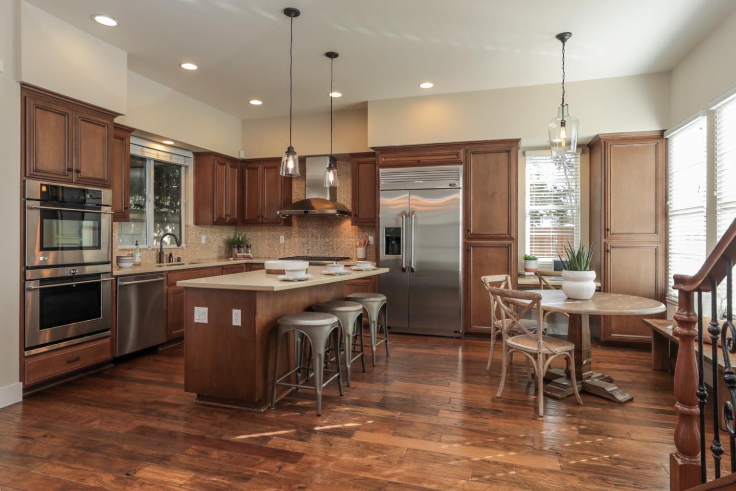 920 Rincon Street Mountain View, CA 94040 - Photo 13 of 45 a kitchen with stainless steel appliances granite countertop a stove top oven a refrigerator a kitchen island a dining table and chairs